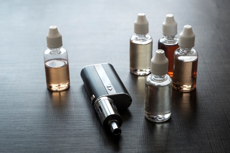 Eine E-Zigarette und verschiedene Vape-Aromen