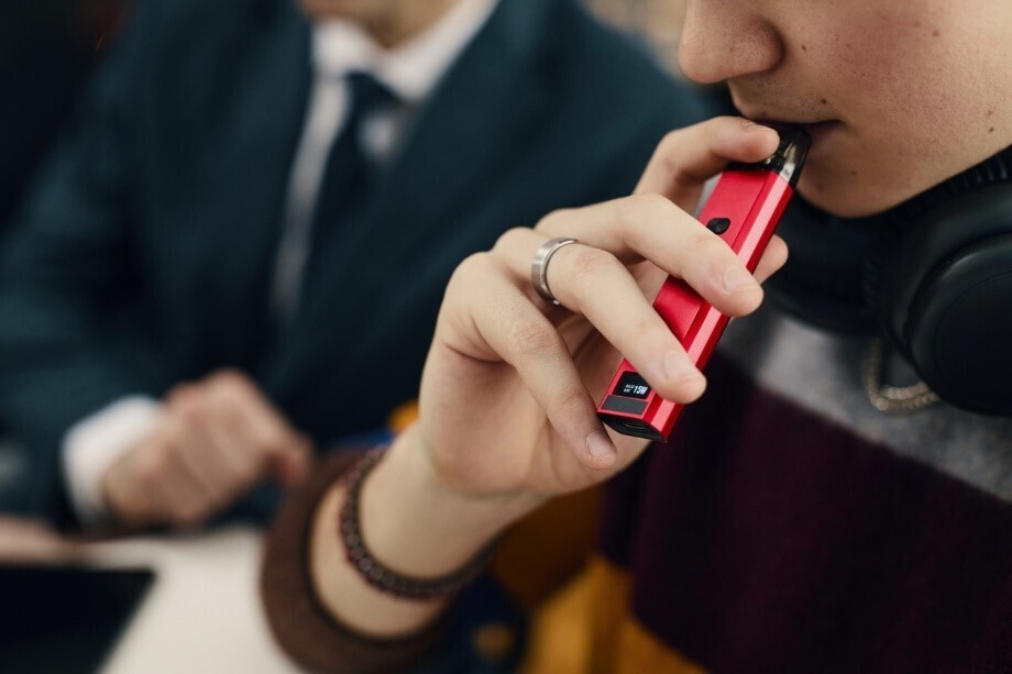 Junger Mann setzt Vape an, um einen Zug zu nehmen