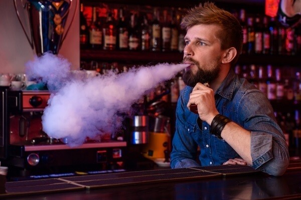 Mann, der eine mit ELFLIQ befüllte Vape raucht