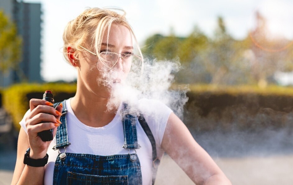 Frau, die eine Vape mit Bestandteilen wie zum Beispiel einem Coil, nutzt