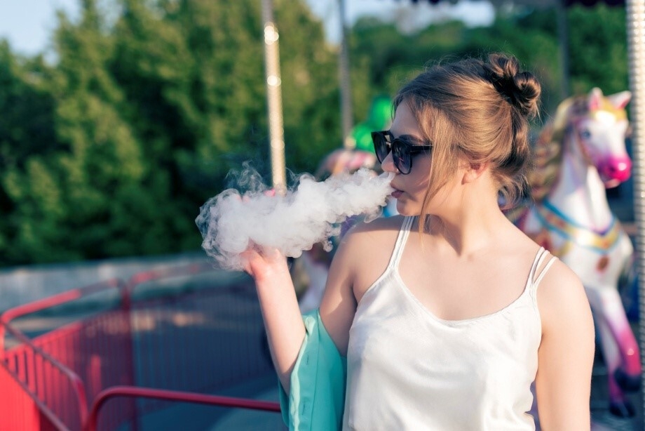 Frau, die auf einem Jahrmarkt eine Vape raucht