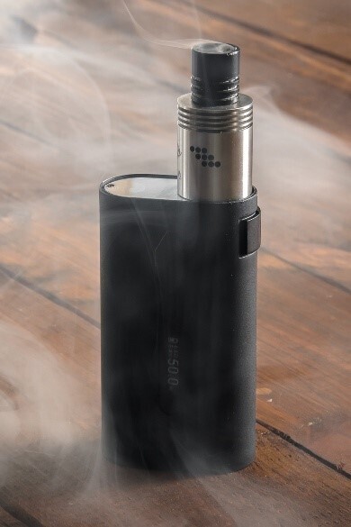 Dampfende Vape steht auf einem Untergrund aus Holz