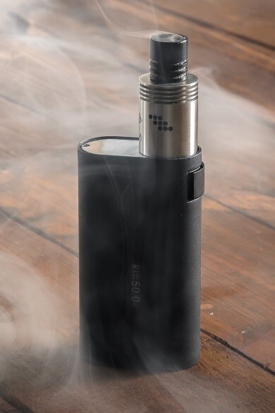 Dampfende Vape steht auf einem Untergrund aus Holz