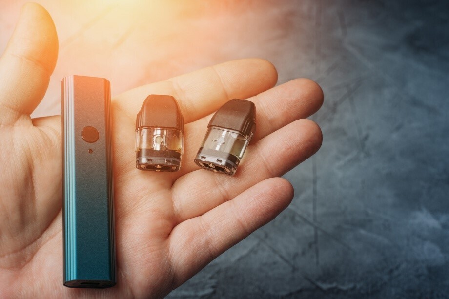 Vape und zwei Pods, die in einer Hand liegen