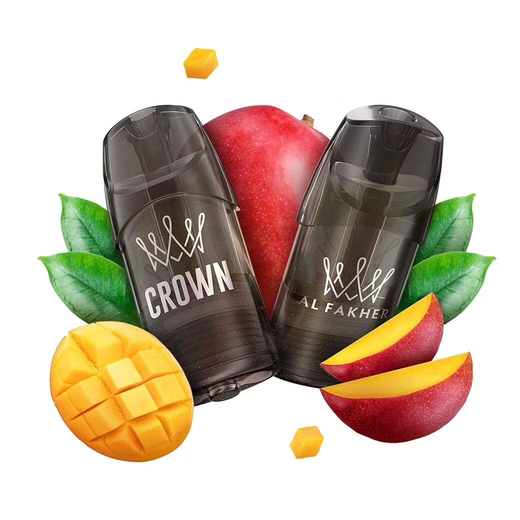 Al Fakher Crown Switch Pods - Tropical Mango 18mg Zwei schwarze Crown und Al Fakher Vaping-Pods mit einem roten Apfel und geschnittenem Mango, umgeben von grünen Blättern und Mangostücken.